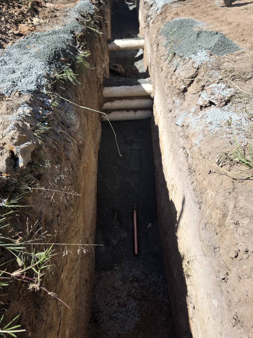 Service trench with pipework and bedding material installed